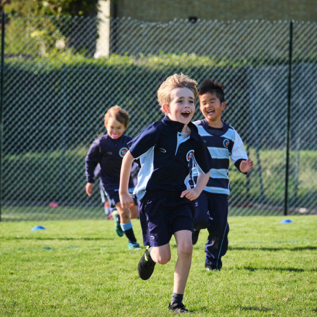 Pupils play rugby at outdoor sports grounds at Dame Bradbury's