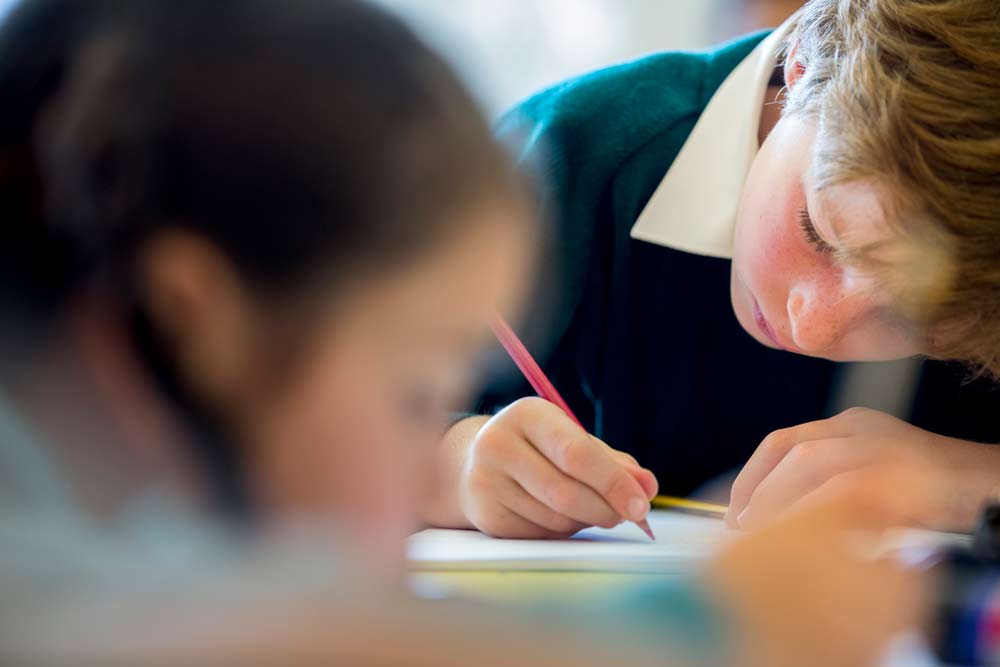 Boy writing in classroom