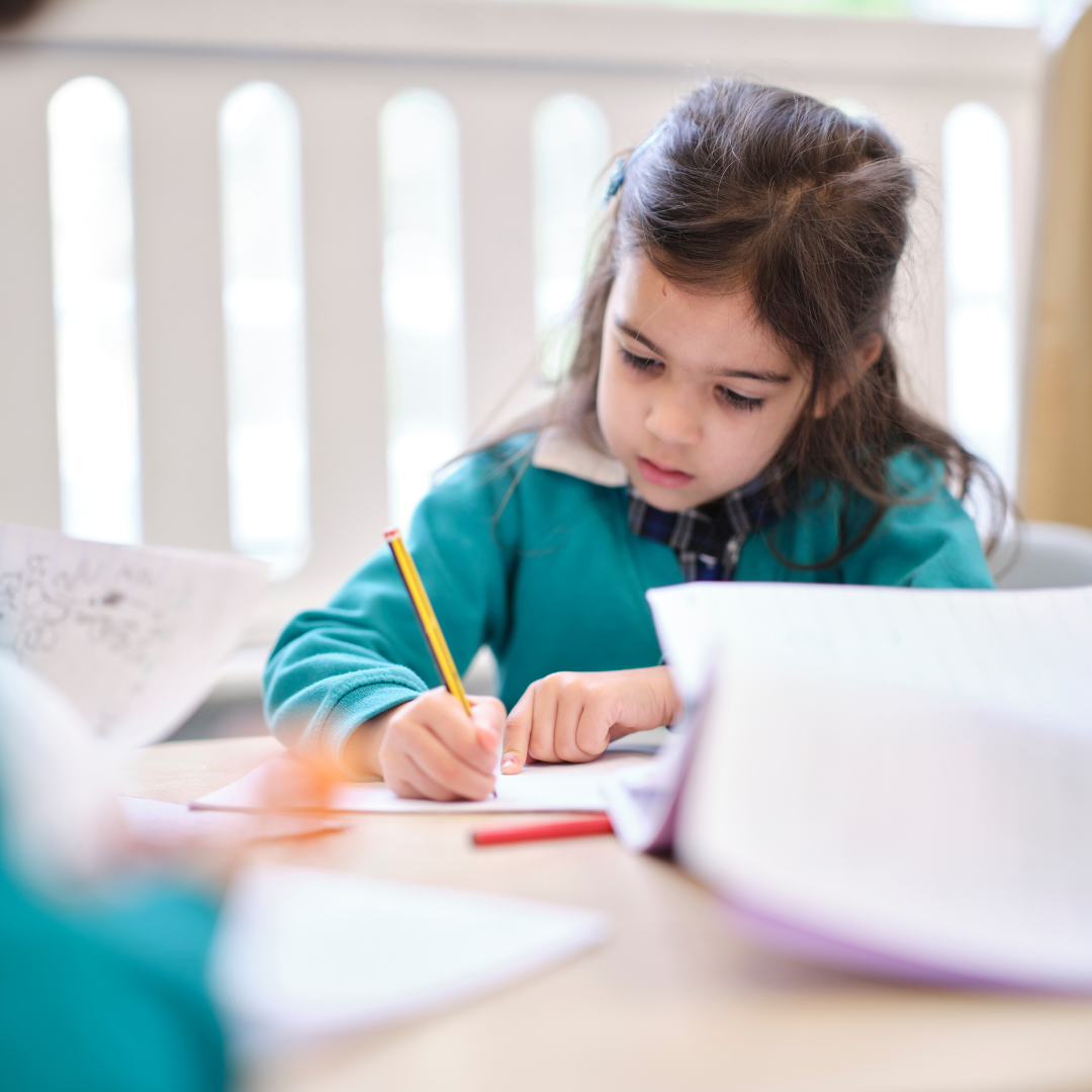 Image of early years pupil writing at a desk